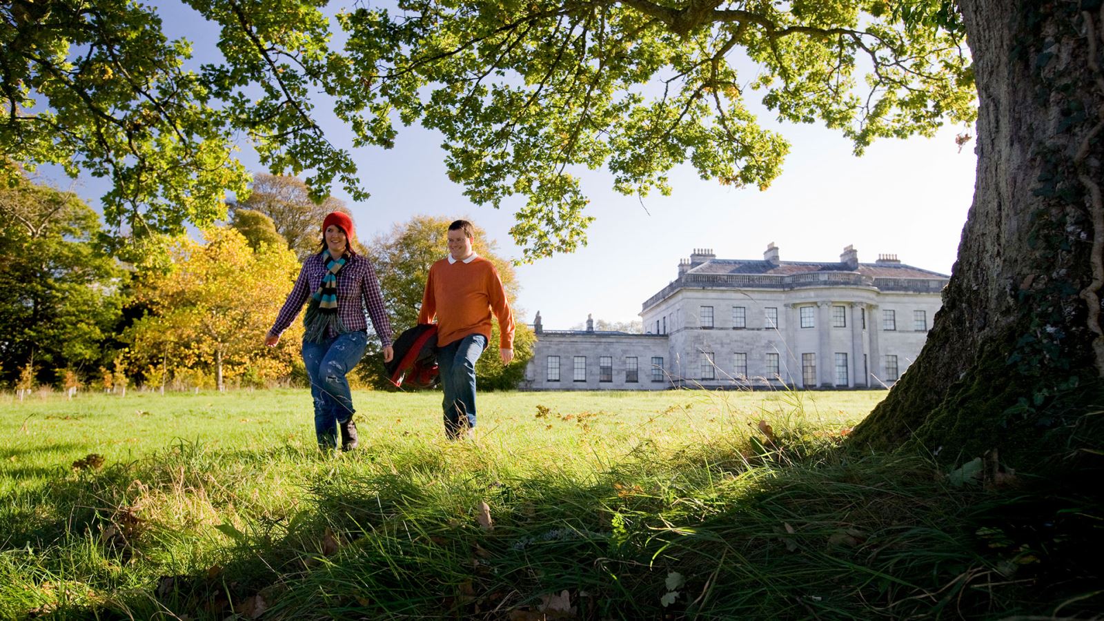 Couple walking in the sunshine at Castle Coole