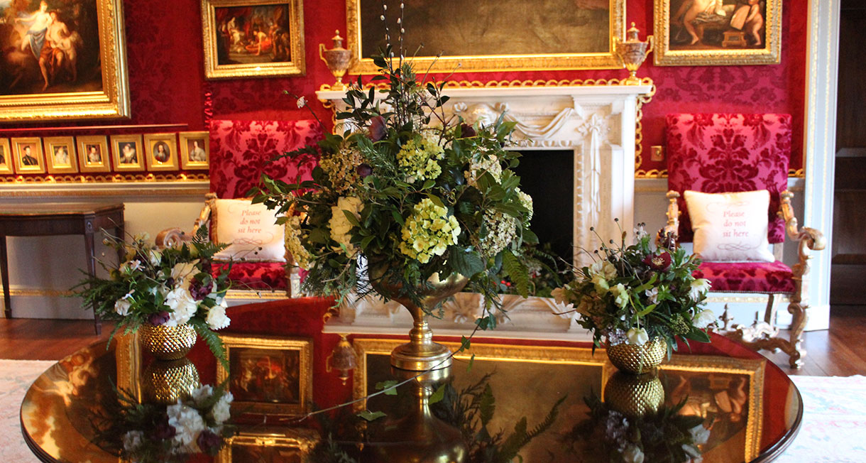 Three Christmas flower arrangements on a table at Hillsborough Castle
