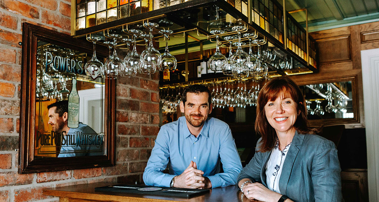 Ronan and Jennie standing at the bar in Balloo House