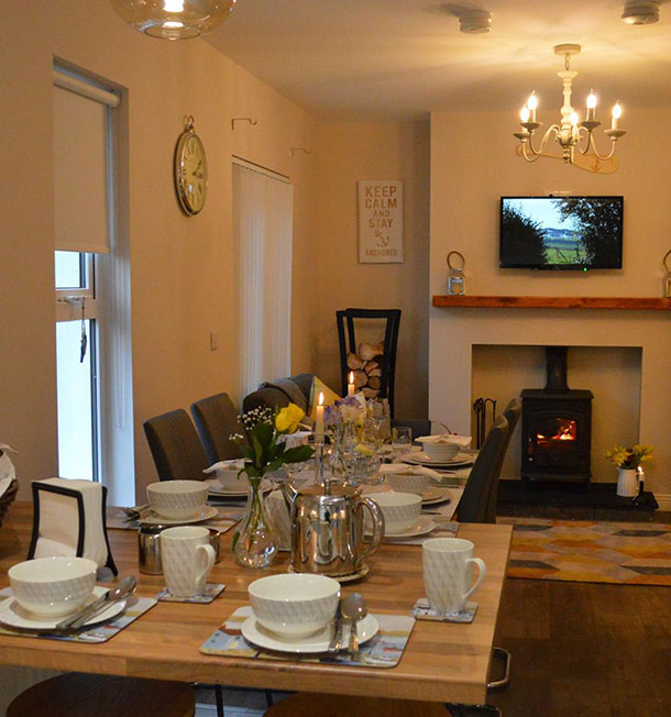 Interior shot of dining table and living area at The Captain's Cottage